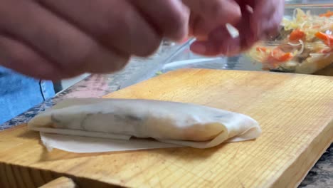 close shot of the hands of a woman doing a spring roll