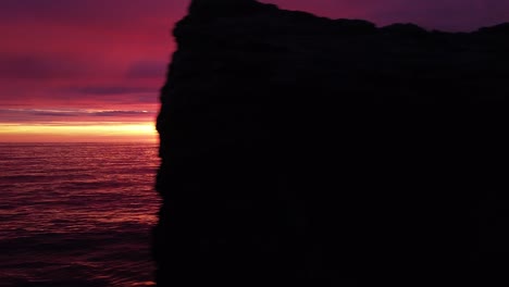 Hermosa-Puesta-De-Sol-Aérea-Vibrante-De-Alto-Contraste-Rosa-Púrpura-Sobre-El-Mar-Báltico,-Ruinas-De-Fortificación-De-La-Costa-De-Hormigón-Del-Puerto-De-Guerra-De-Karosta-En-Liepaja,-Gran-Angular-Drone-Dolly-Moviéndose-Hacia-La-Derecha