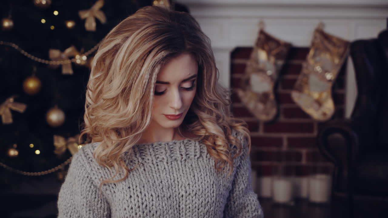 Woman opening gift boxes. Young woman with presents in New Year interior in the living room