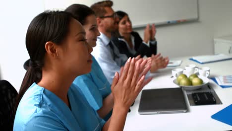equipo de médicos aplaudiendo durante una reunión