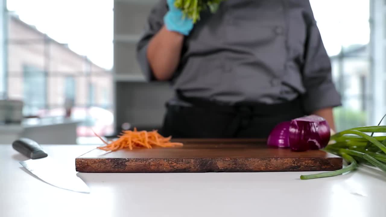 el chef coloca el perejil en la tabla de cortar a cámara lenta
