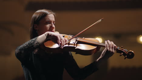 Una-Violinista-Inspirada-Está-Tocando-Una-Melodía-En-Una-Orquesta-Sinfónica.-Retrato-De-Un-Violinista-En-Escena.