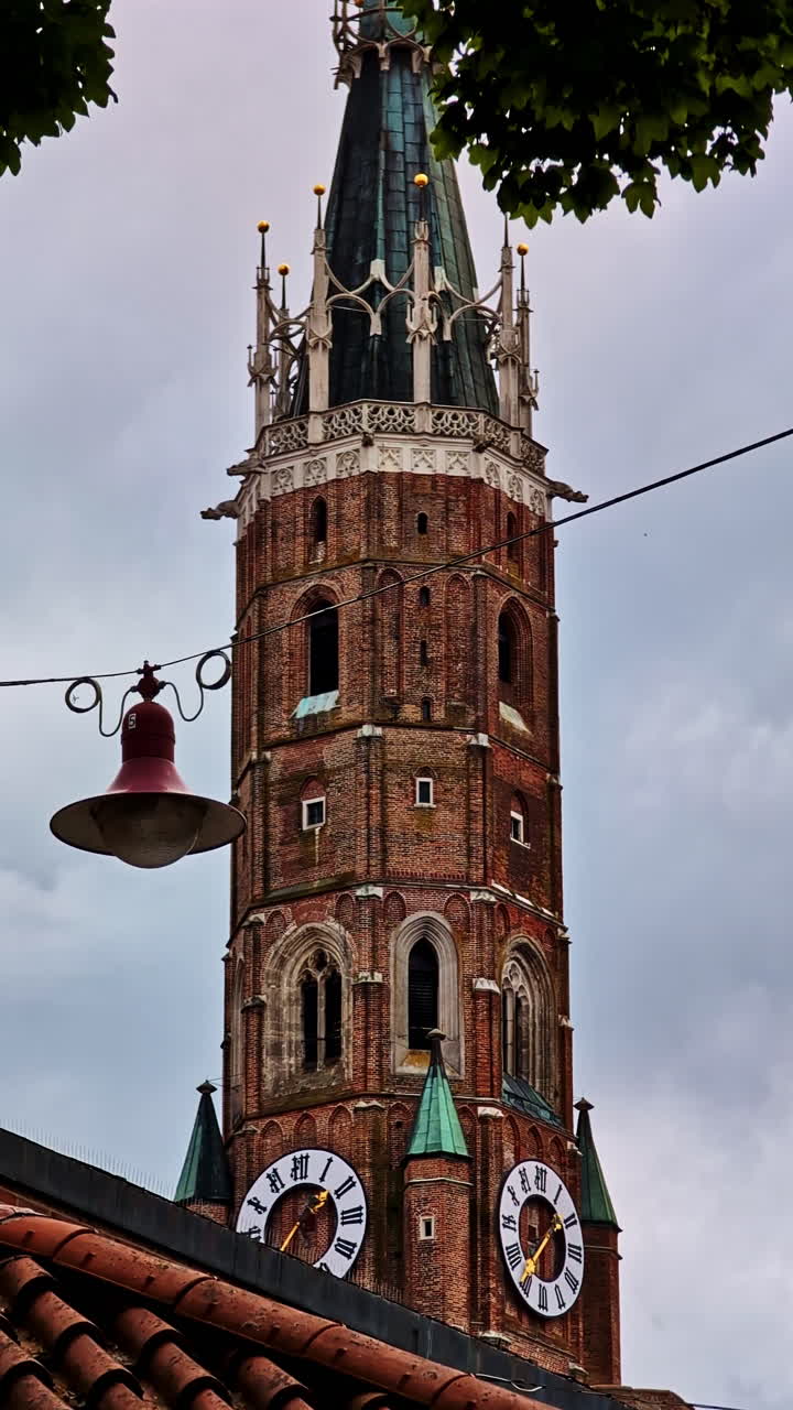 Towering Clock Spire of St. Martin’s Church Rises Over Old Town of Landshut in Vertical shot