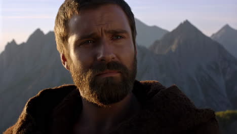 portrait of a bearded man in front of mountains