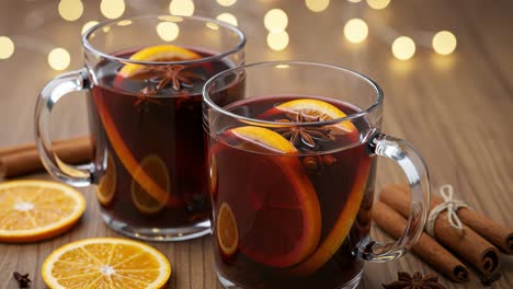 Two mugs of festive mulled wine with orange and spices