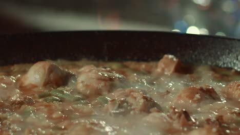 trozos de pollo están siendo cocinados en una sartén grande