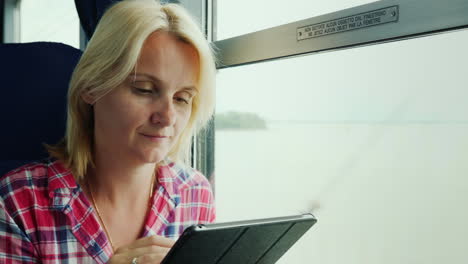 Mujer-Usando-Una-Tableta-Por-Ventana-Tain