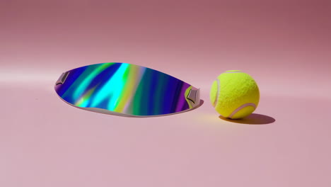holographic visor and tennis ball on pink background