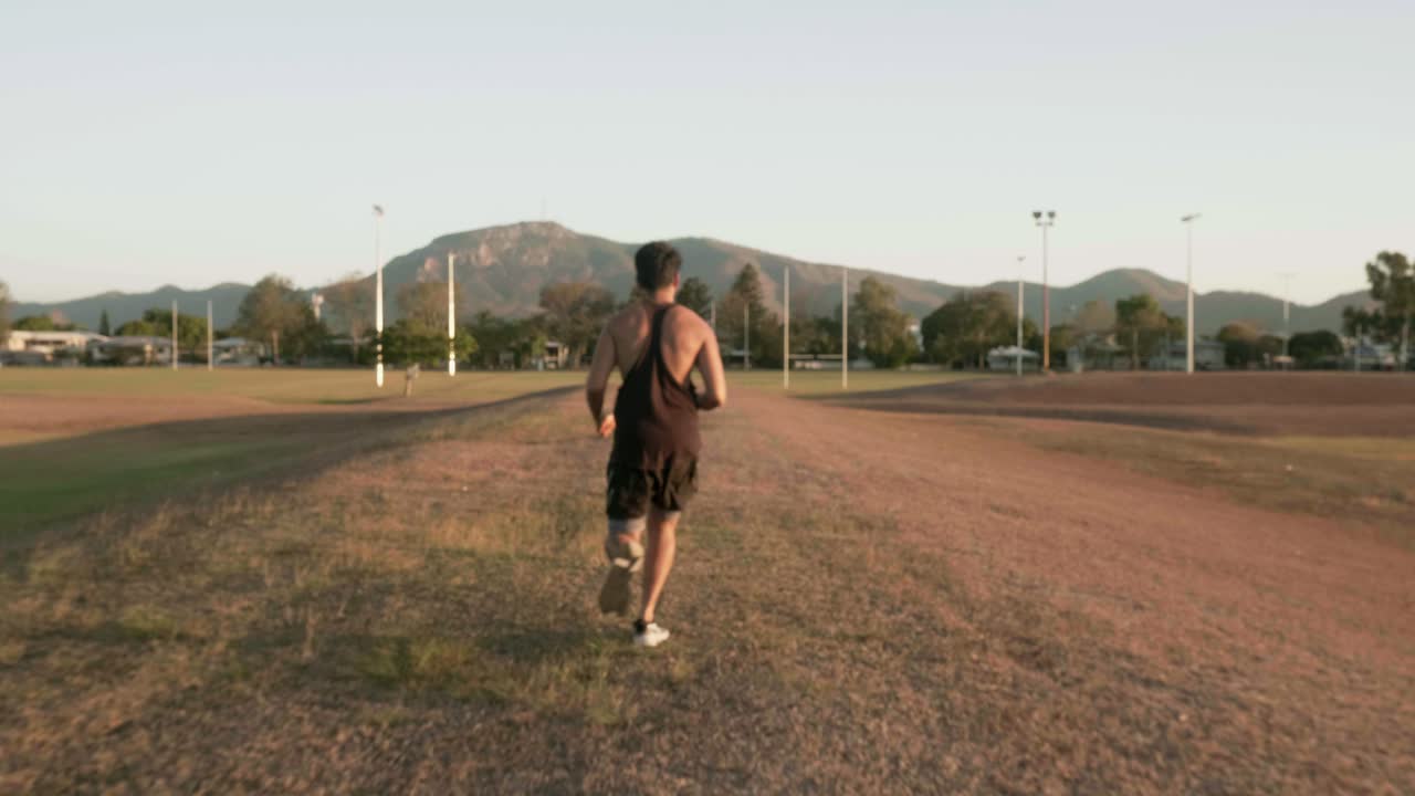 chico indio corriendo y entrenando para hacer ejercicio cardiovascular en un parque público durante la puesta de sol