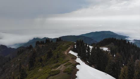 aerial above mountain peak and mountain valley on horizon while rainy weather