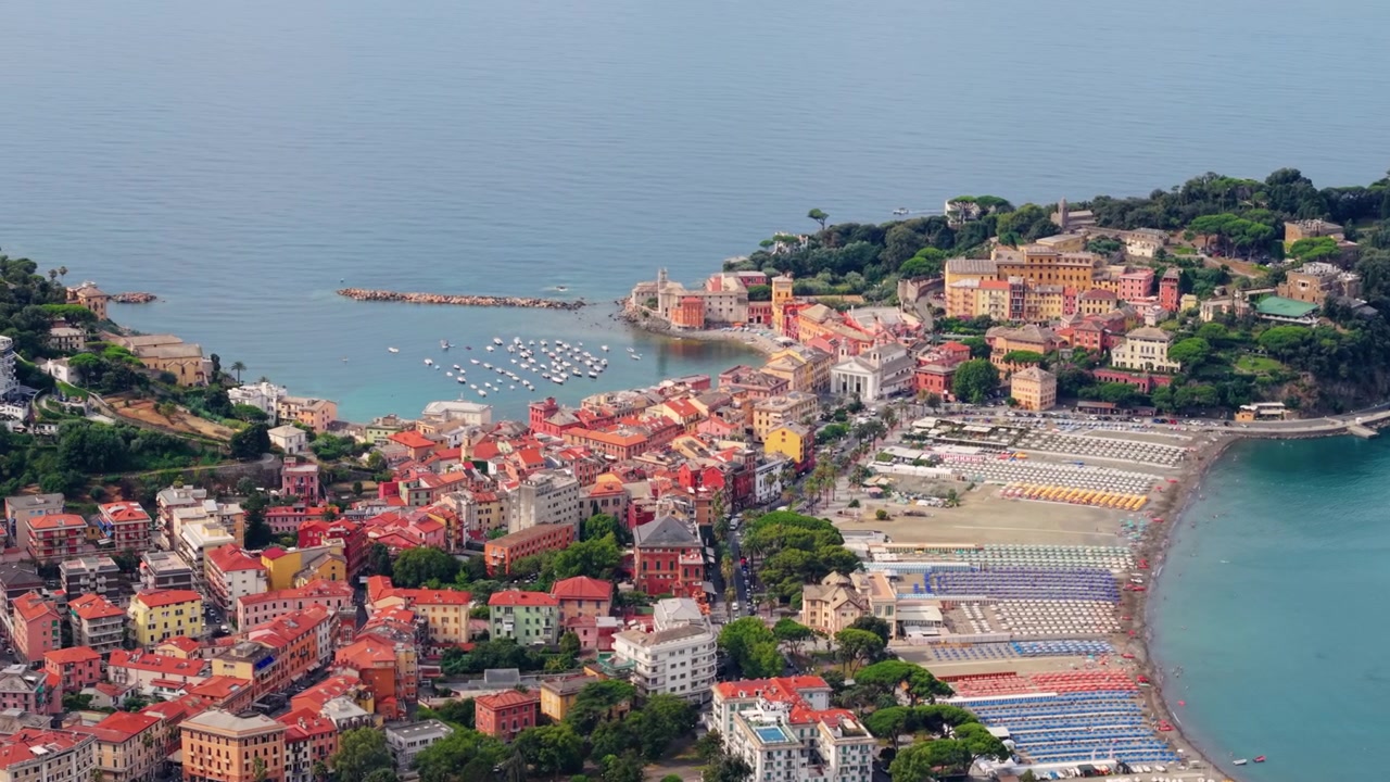 Tetti colorati riempiono Sestri Levante mentre il drone effettua una panoramica dalla cala alla spiaggia.