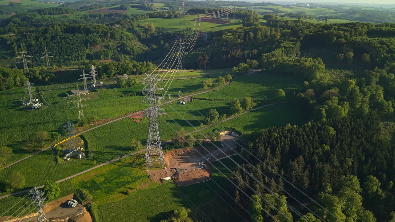 High voltage electricity pylons and transmission cables across green countryside in Germany