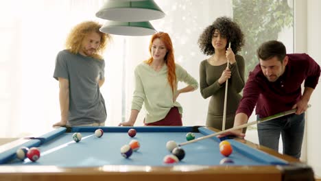 friends having nice rivalry playing pool together at home
