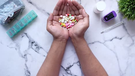manos sosteniendo pastillas variadas con suministros médicos