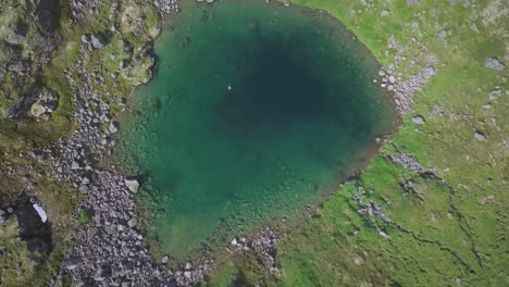 rising drone shot of an isolated glacial lake in alaska's hatcher pass