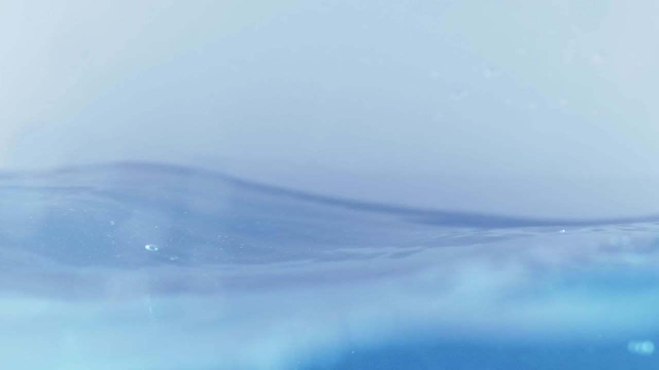 슬로우 모션의 깨끗한 물 표면은 물이 튀는 상점으로 화면을 채우고 기포로 액체 표면을 흔들고 있습니다.