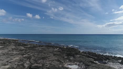 Drohne-Fliegt-über-Mann-Auf-Vulkanischen-Felsen-Am-Ko-Olina-Beach-Shore,-Hawaii