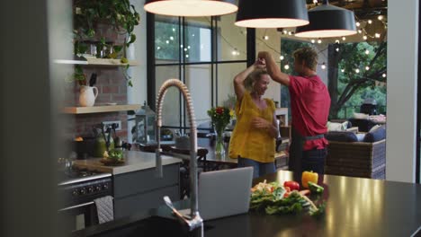 pareja feliz bailando en la cocina