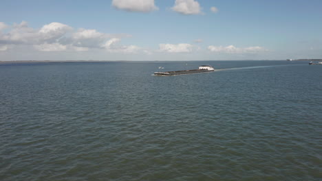 Aerial-of-cargo-ship-carrying-sand-driving-over-sea