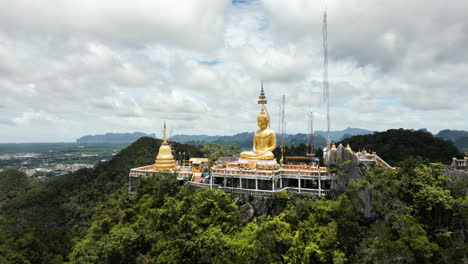 golden buddha statue on mountain top overlooking krabi, tiger cave temple, wat tham suea