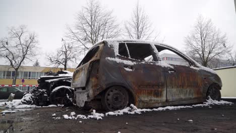 arson car vandalism, city crime scene burnt vehicle covered in snow