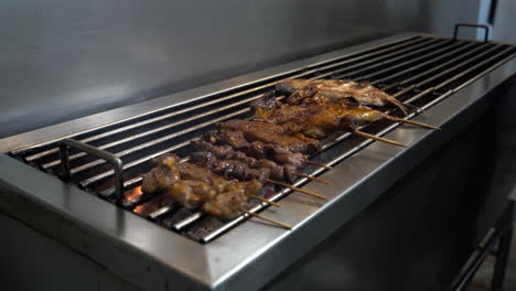 chicken and chicken liver skewers griller on stainless griller. - close up, handheld