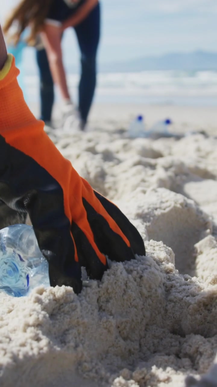 Animación de corazones sobre voluntarias diversas recogiendo basura en la playa