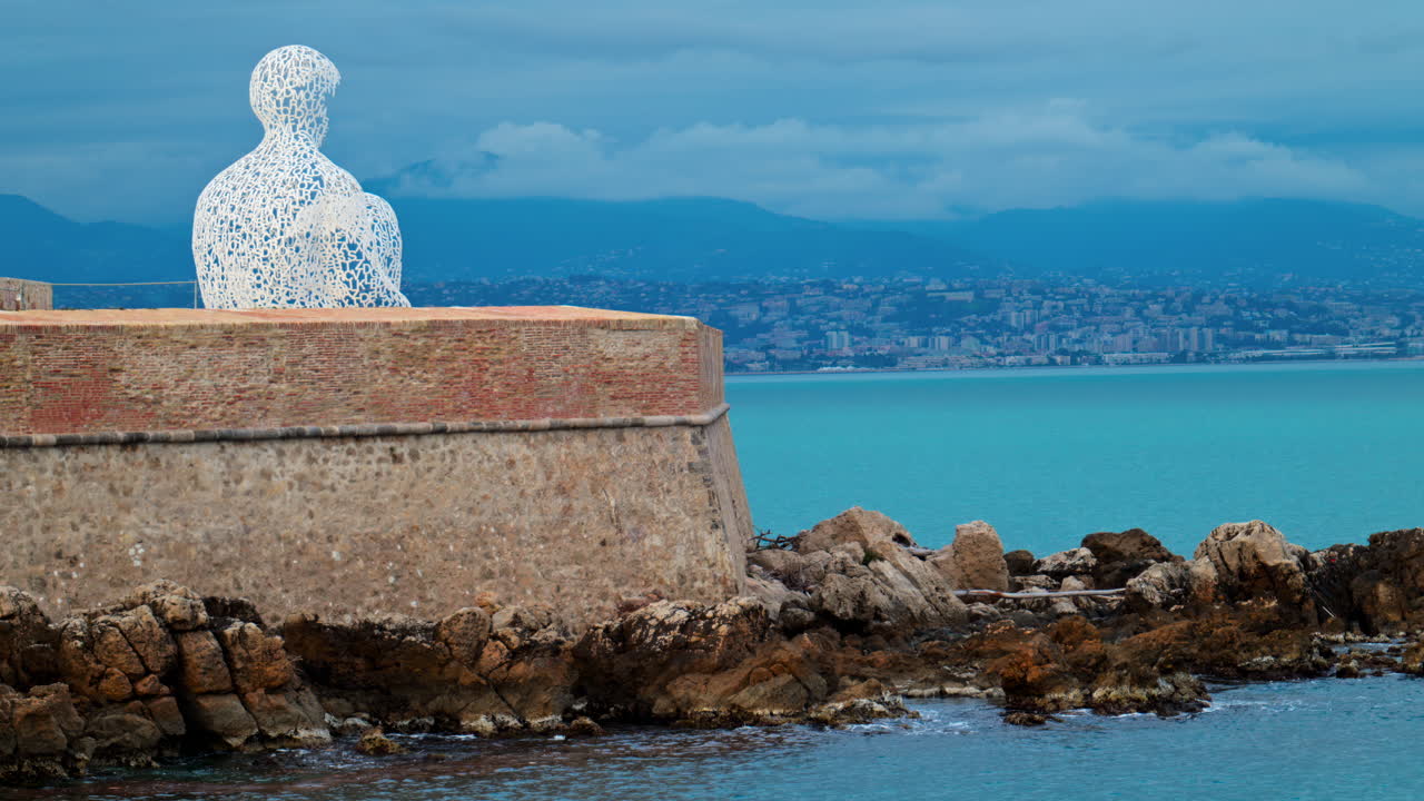 Distant view of The Nomad urban sculpture by Jaume Plensa in the evening in Antibes, France