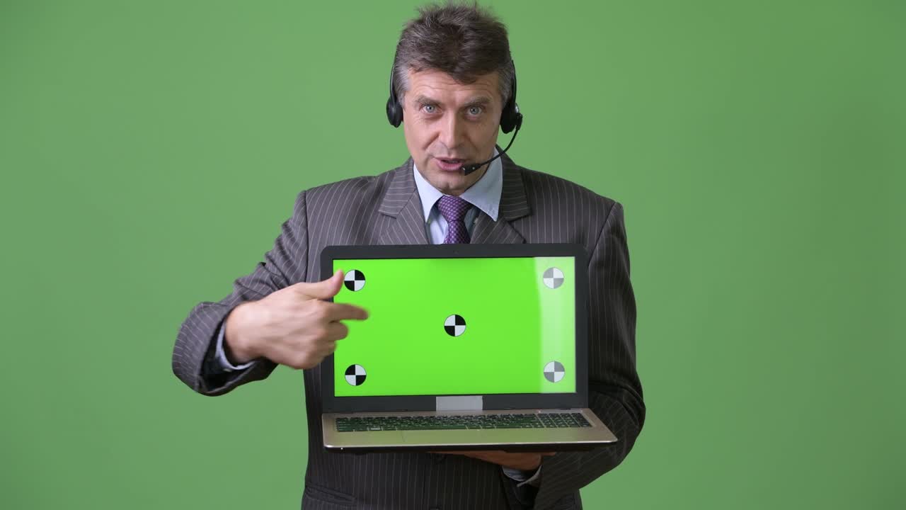 hombre de negocios maduro y guapo contra un fondo verde