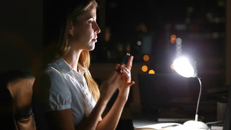 una mujer de negocios haciendo una llamada telefónica por la noche.