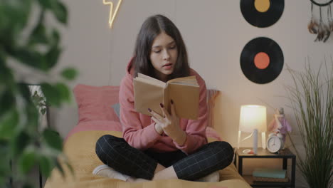 teenage girl reading in bedroom