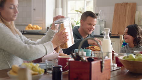 happy family eating breakfast together parents preparing cereal for children in kitchen at home