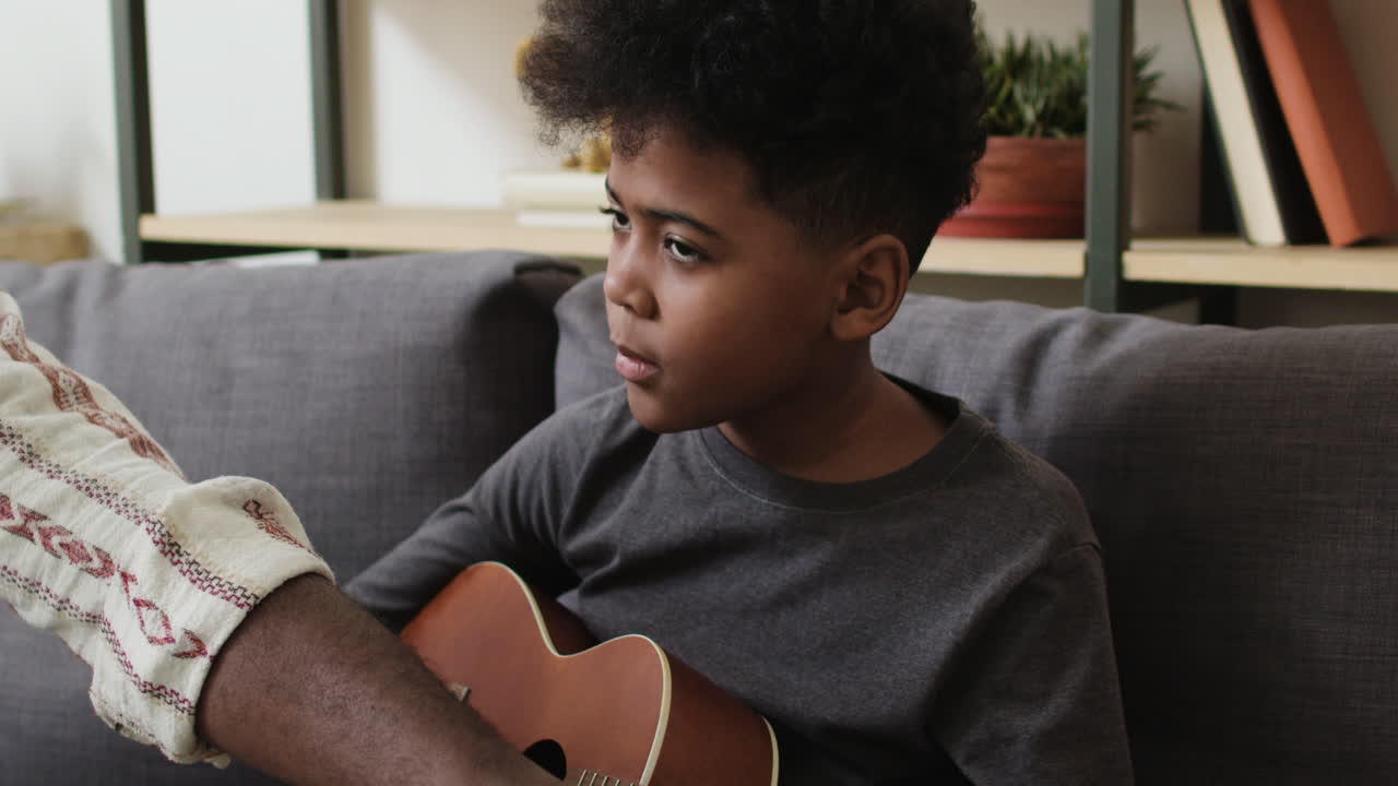Ragazzo che impara a suonare l'ukulele