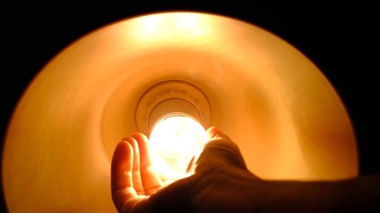 전기공의 손이 전구를 교체하고 있습니다. 등불을 켜세요.