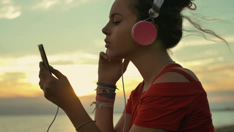 teenager girl with headphones listening music on the beach. shot in slow motion