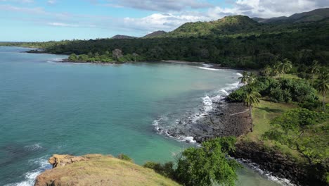 drone view of a tropical coastline with green hills and palm trees on grande comore