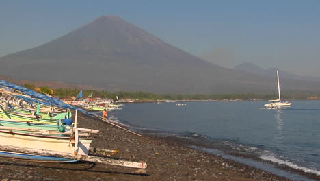 pequeñas olas en una orilla bordeada de botes en indonesia
