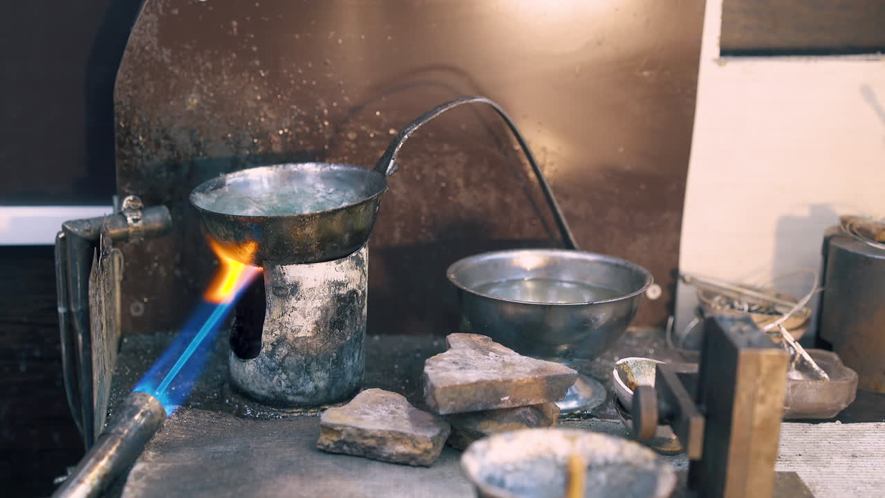 남자가 뜨거운 액체 클로즈업으로 그 ⁇ 에서 금 세부 사항을 제거합니다.