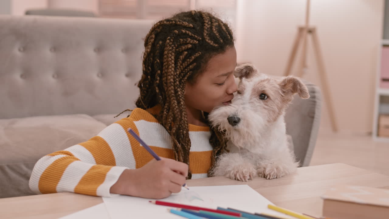 아프리카 소녀가 그림을 그리고 키스하는 개