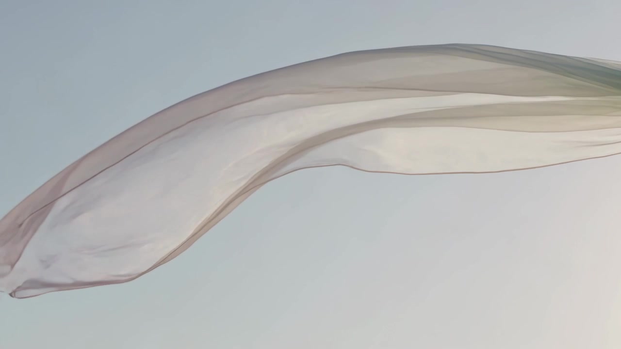 Billowing sheer translucent fabric flowing across clear sky under steady breeze and sunlight