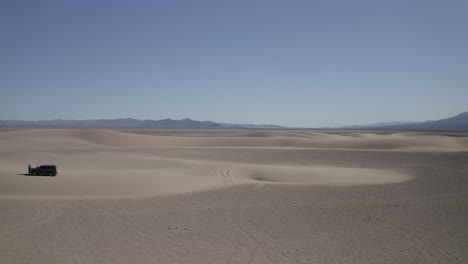 Aerial-drone-over-sand-dunes,-lone-4x4-vehicle,-WIDE