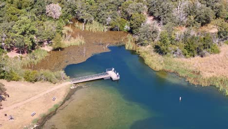 A-wide-shot-of-a-slow-clockwise-spin-around-a-fishing-pier-on-a-small-inlet-on-the-lake