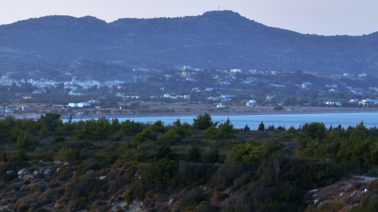 Telephoto aerial revealing the coastline of Kolympia, sunset in Rhodes, Greece