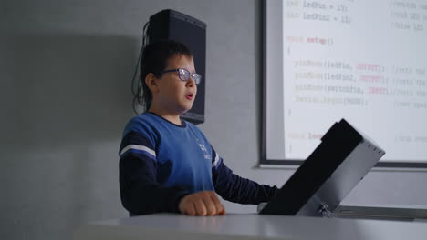 junge demonstriert programmiercode auf einem laptop