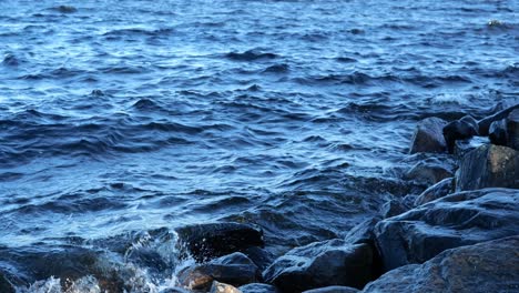 water hitting rocks at shore