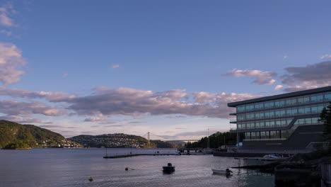 The-Askoy-bridge-in-Bergen,-Norway-in-the-distance-as-ships-move-on-the-water-and-clouds-roll-across-the-sky