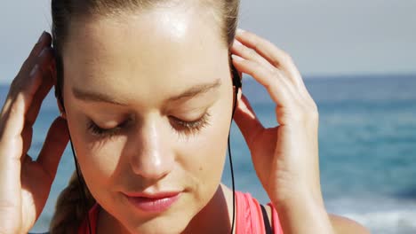 hermosa mujer poniendo auriculares en su oído antes de correr