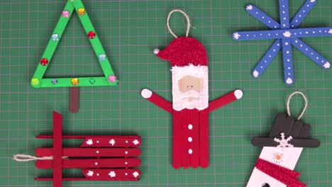 christmas ornaments made with popsicle sticks on a cutting mat