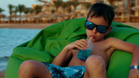 Young-man-having-fun-at-seashore-in-summer.-Teenage-boy-sitting-at-seaside.