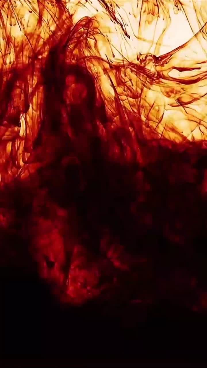 Dunkelrote Tinte breitet sich aus und wirbelt im Wasser